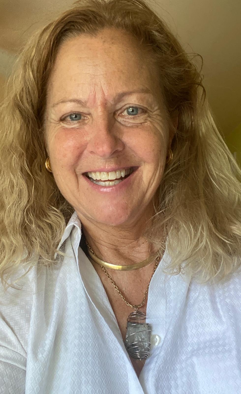 Rita Lorraine Carey smiling, wearing a wire-wrapped crystal pendant